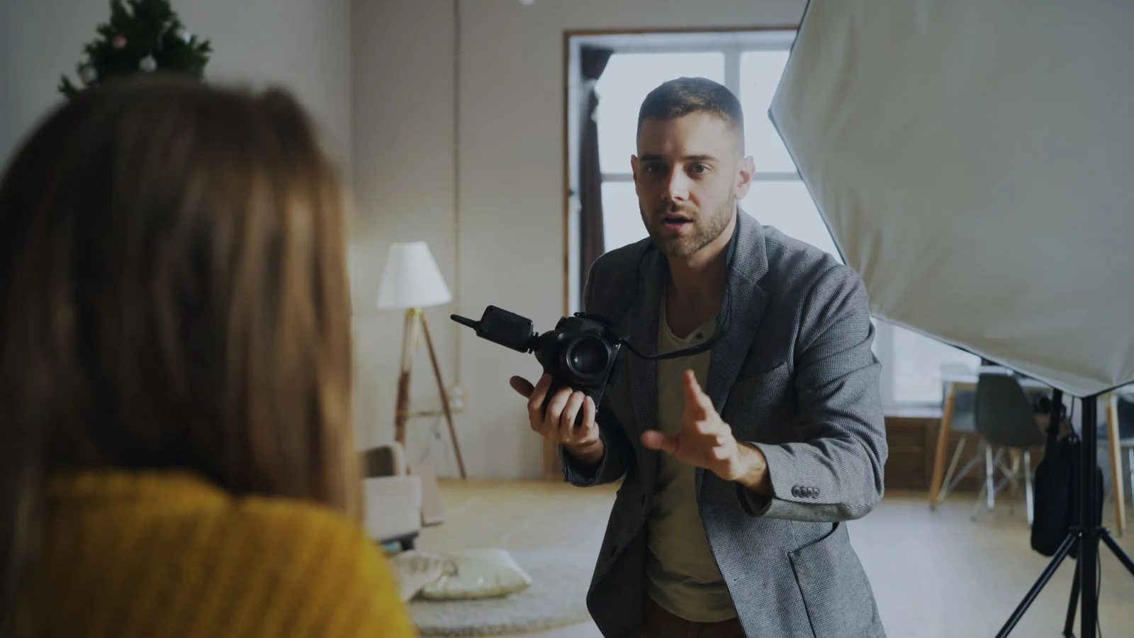 Un photographe échange avec sa cliente dans son studio, appareil en main
